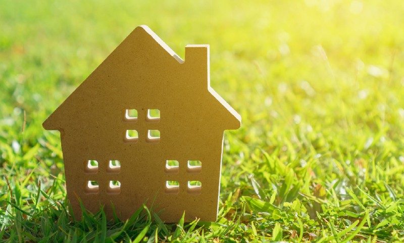 sustainable green building 2-D model of house standing on green grass