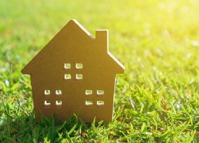 sustainable green building 2-D model of house standing on green grass